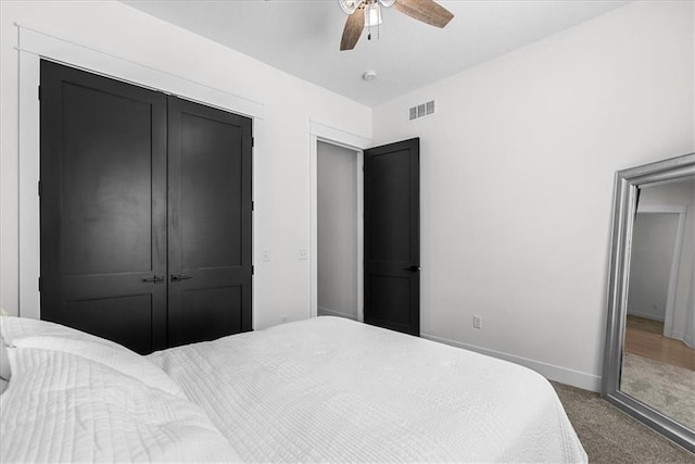 carpeted bedroom featuring ceiling fan and a closet