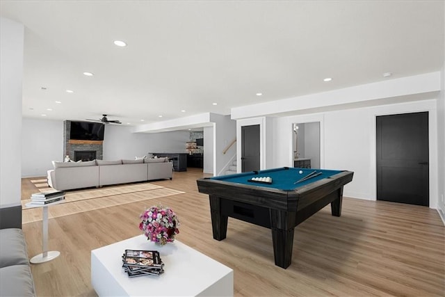 rec room featuring ceiling fan, a fireplace, light hardwood / wood-style flooring, and billiards