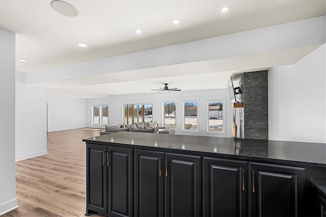 bar featuring ceiling fan and light hardwood / wood-style flooring