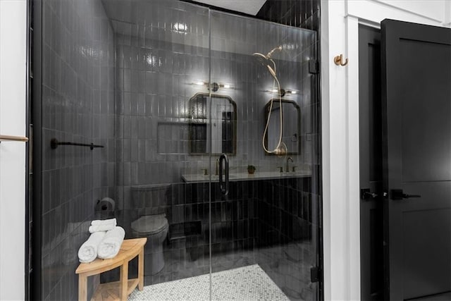 bathroom featuring toilet, tile patterned flooring, and an enclosed shower