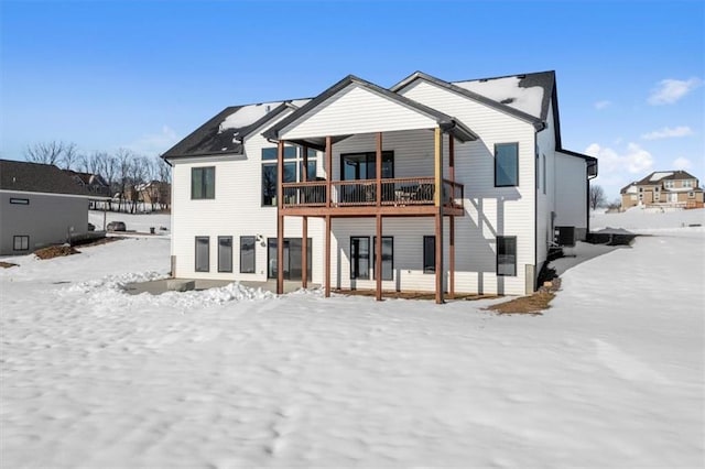 snow covered rear of property featuring central air condition unit