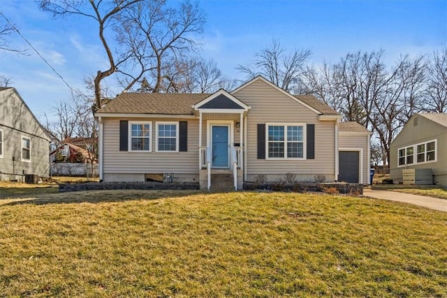 bungalow-style home with driveway, central AC unit, and a front yard