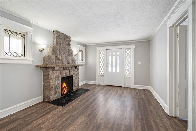 entryway with ornamental molding, dark wood-type flooring, a fireplace, and a textured ceiling