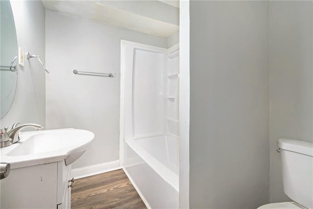 full bathroom featuring washtub / shower combination, wood-type flooring, toilet, and vanity