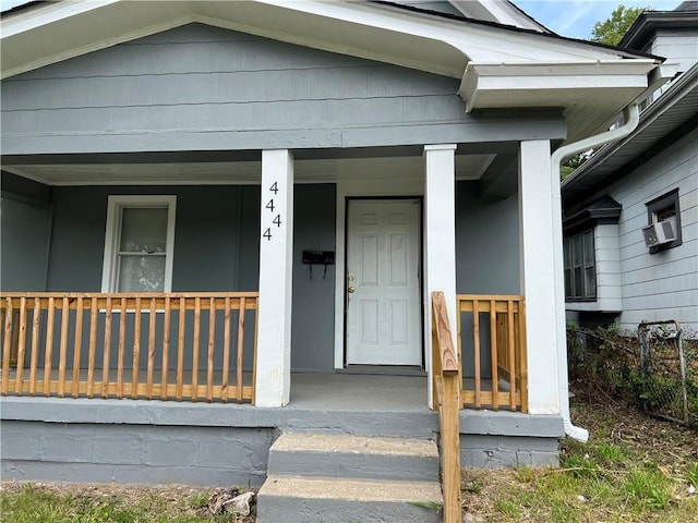 view of exterior entry featuring covered porch