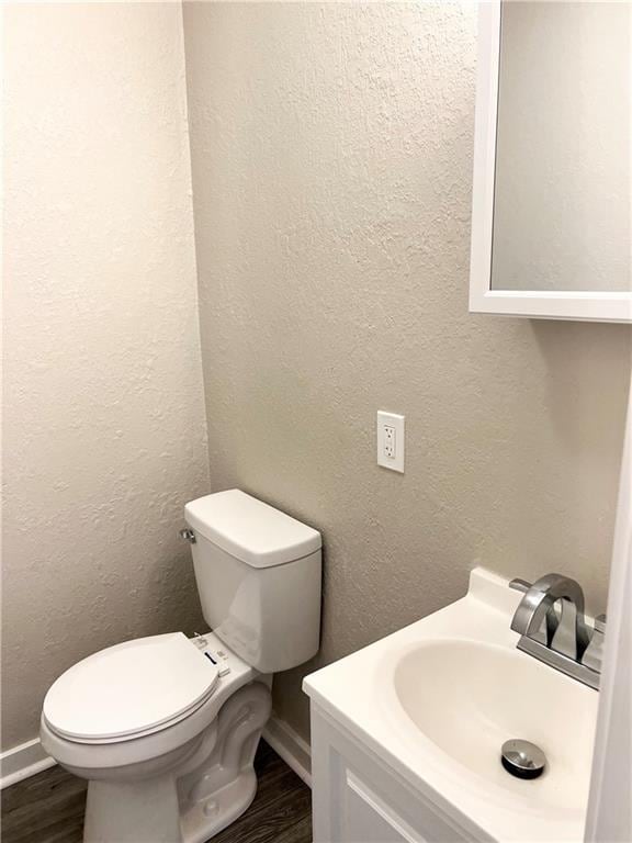 bathroom featuring hardwood / wood-style flooring, vanity, and toilet