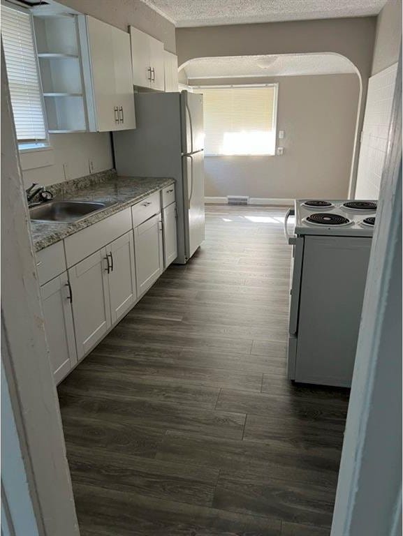 kitchen featuring white cabinetry, sink, and white range with electric stovetop