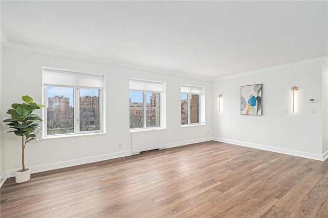 spare room featuring crown molding, radiator heating unit, and hardwood / wood-style flooring