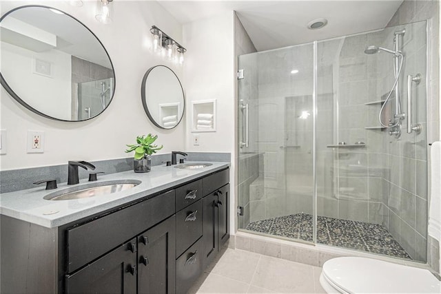 bathroom with vanity, toilet, a shower with shower door, and tile patterned flooring