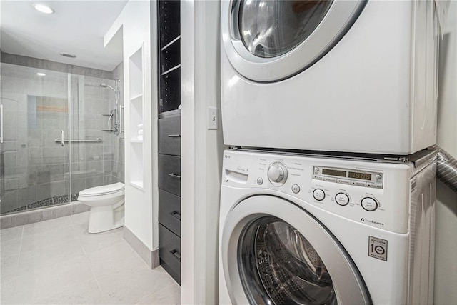 laundry room featuring light tile patterned floors and stacked washer and clothes dryer