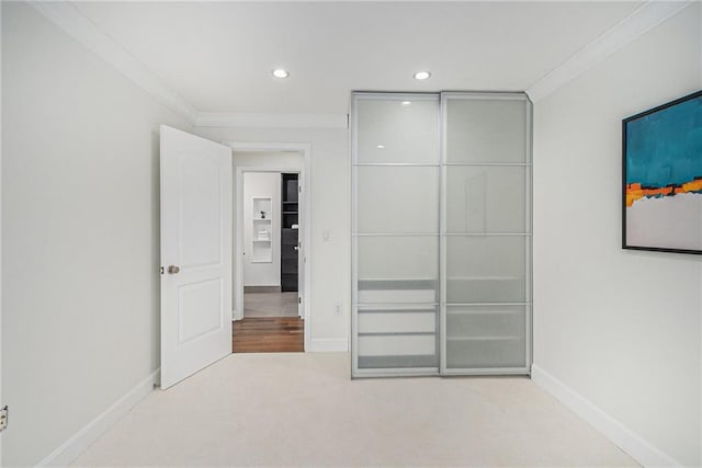 unfurnished bedroom with crown molding and light colored carpet