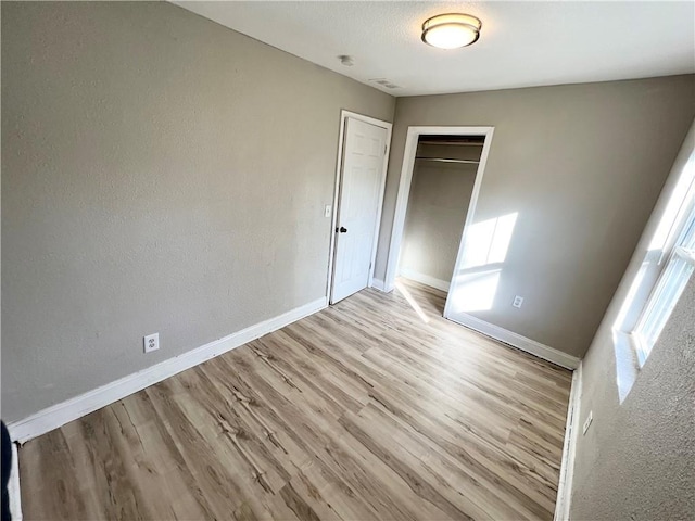 unfurnished bedroom with light hardwood / wood-style floors and a closet