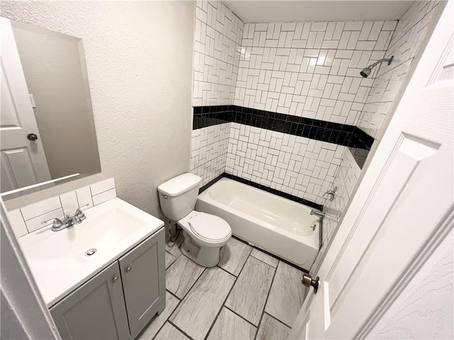 full bathroom with vanity, toilet, and tiled shower / bath combo