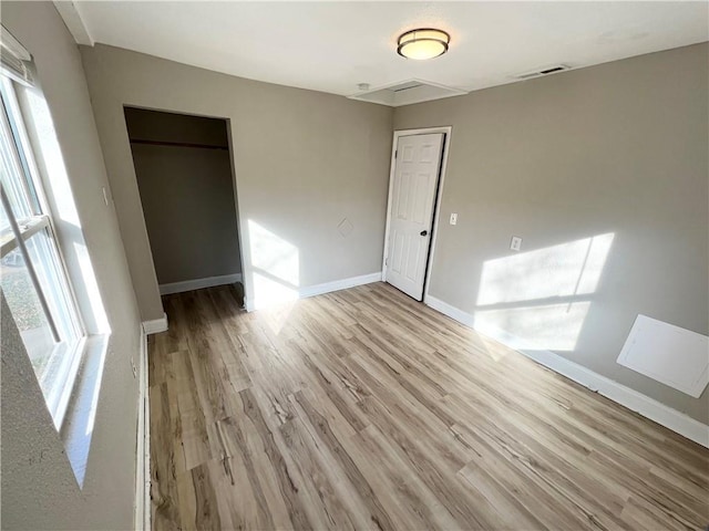 unfurnished room featuring a healthy amount of sunlight and light hardwood / wood-style flooring