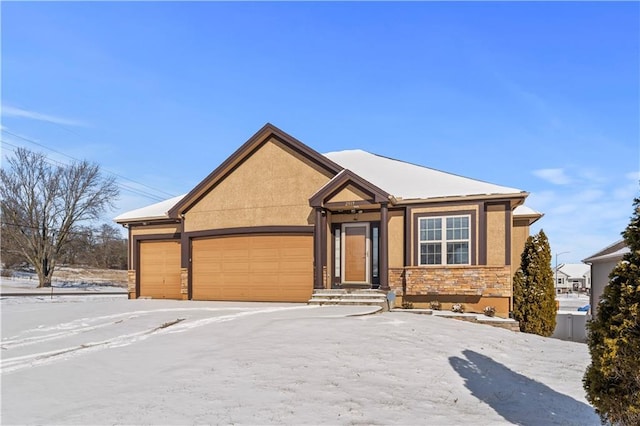 view of front facade featuring stone siding, an attached garage, and stucco siding