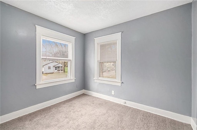 carpeted empty room with a textured ceiling