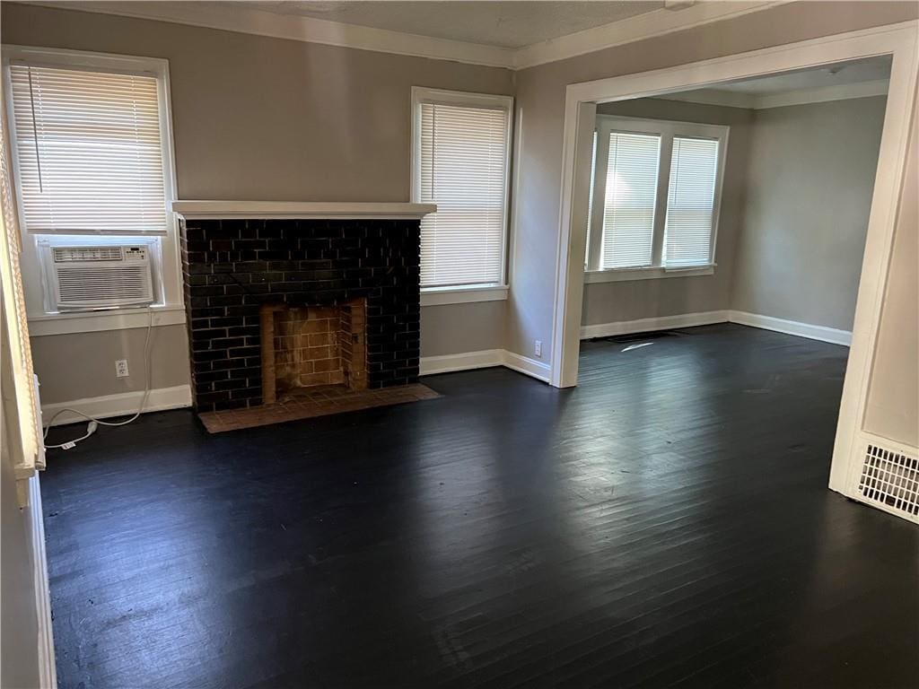 unfurnished living room featuring dark hardwood / wood-style floors, ornamental molding, a fireplace, and cooling unit