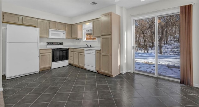 kitchen with dark tile patterned floors, sink, light brown cabinets, and white appliances