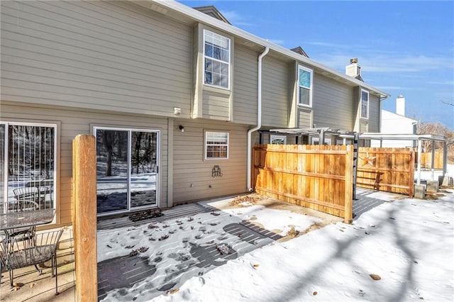 view of snow covered rear of property