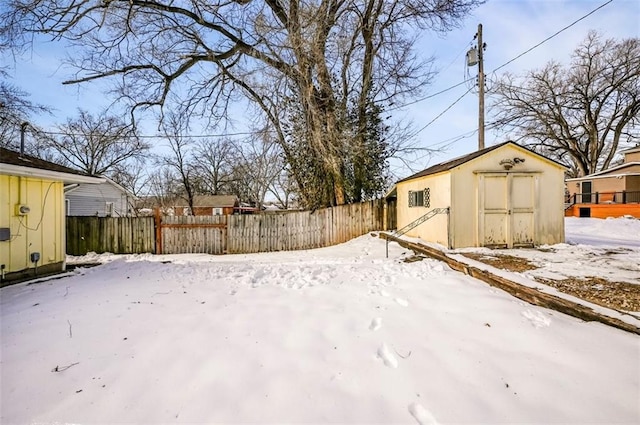 snowy yard featuring a storage shed