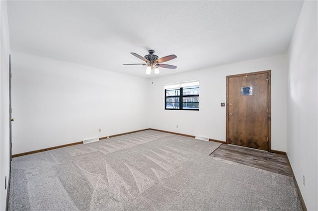 spare room featuring ceiling fan and light carpet