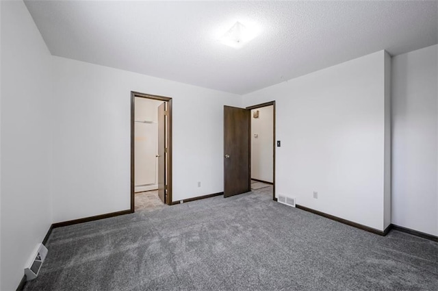 unfurnished bedroom with carpet flooring, a textured ceiling, and a baseboard heating unit