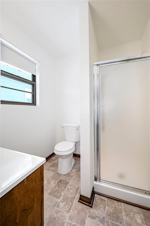 bathroom featuring vanity, toilet, and a shower with shower door