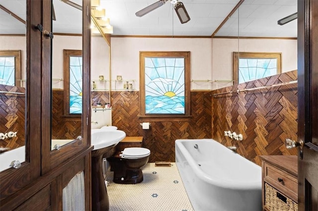 bathroom featuring tile patterned floors, toilet, ornamental molding, ceiling fan, and a washtub