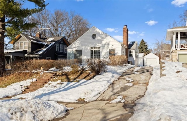 view of front of home featuring a garage and an outbuilding