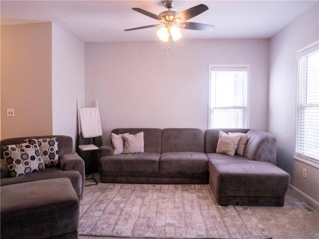 carpeted living room with ceiling fan