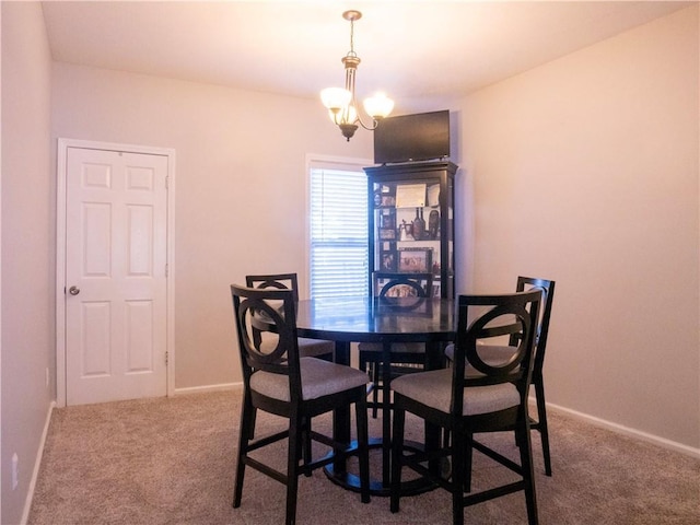 dining space featuring a notable chandelier and carpet flooring