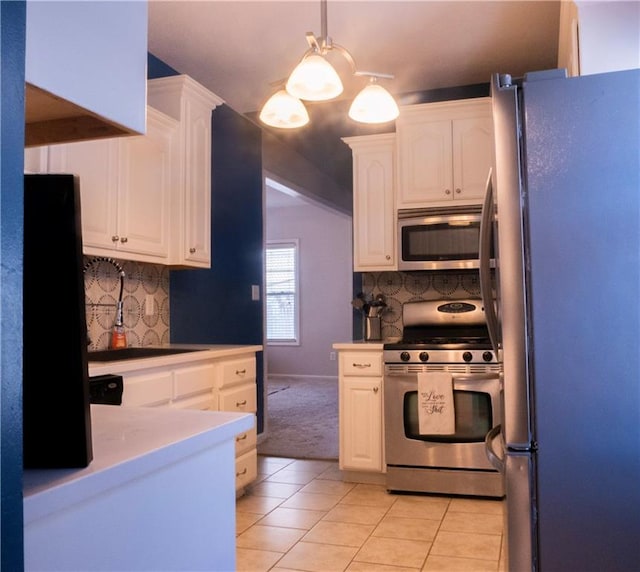 kitchen with white cabinetry, pendant lighting, appliances with stainless steel finishes, and light tile patterned floors