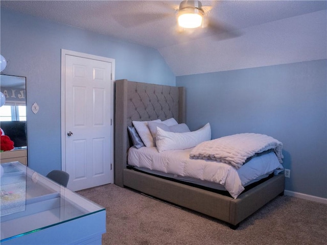 carpeted bedroom featuring ceiling fan, lofted ceiling, and a textured ceiling