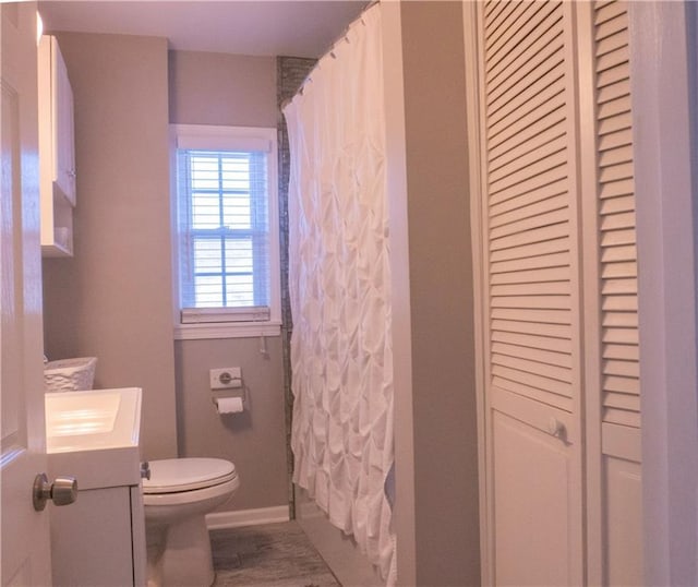 full bathroom featuring hardwood / wood-style flooring, vanity, toilet, and shower / bath combo