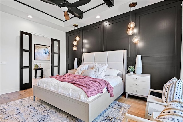 bedroom with recessed lighting, a decorative wall, light wood finished floors, and ceiling fan