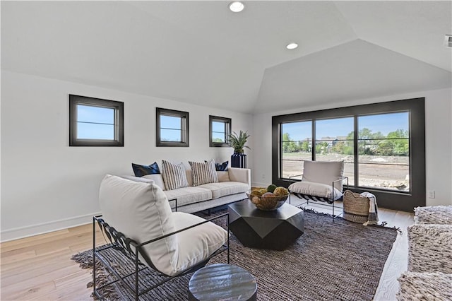 living room with lofted ceiling, baseboards, and light wood-style floors