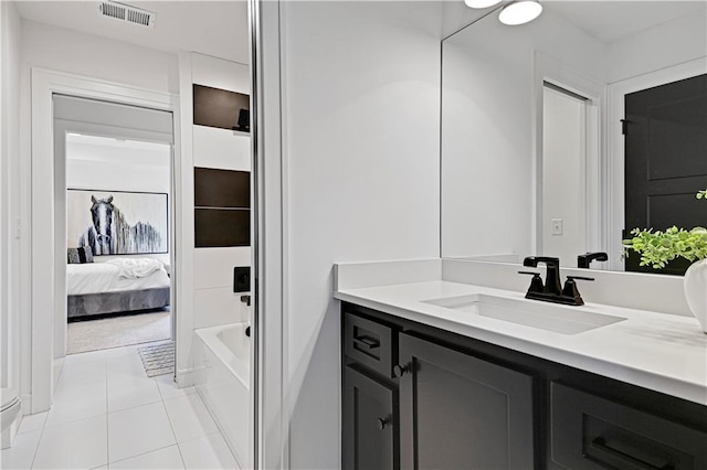 ensuite bathroom with vanity, connected bathroom, visible vents, and tile patterned floors