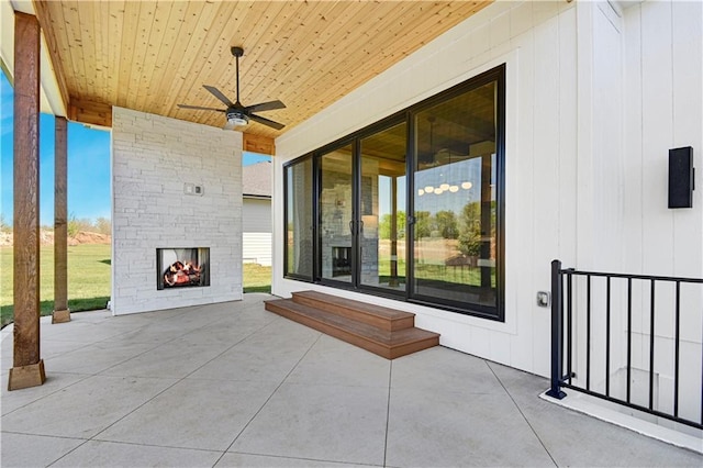 view of patio / terrace with ceiling fan and a fireplace