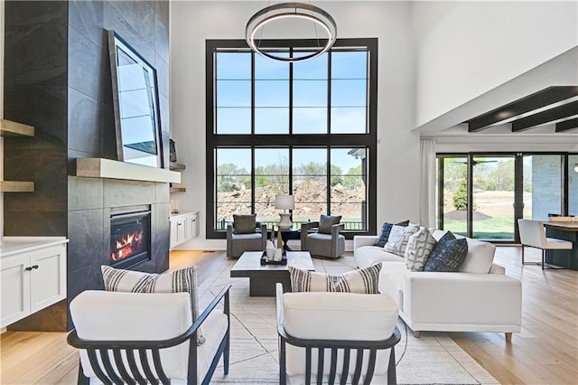 16920 Parkhill St, Overland Park, KS 66221 - living area with a tile fireplace, light wood-type flooring, and a towering ceiling