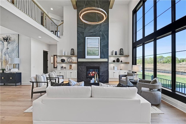 16920 Parkhill St, Overland Park, KS 66221 - living area with a towering ceiling, baseboards, wood finished floors, a high end fireplace, and recessed lighting