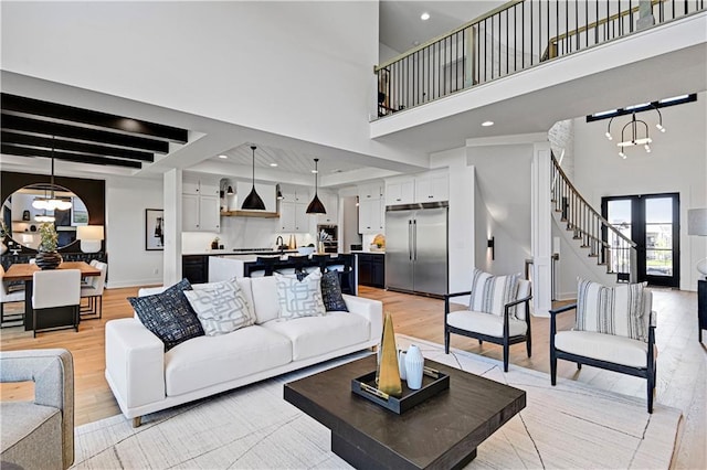 16920 Parkhill St, Overland Park, KS 66221 - living area featuring light wood-type flooring, a chandelier, a high ceiling, stairway, and recessed lighting
