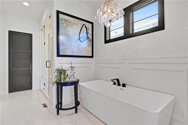 16920 Parkhill St, Overland Park, KS 66221 - full bathroom featuring a decorative wall, a freestanding tub, a stall shower, a chandelier, and wainscoting