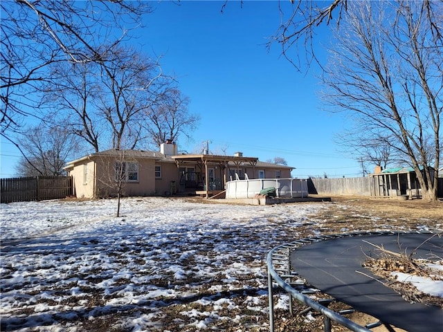 view of snow covered back of property