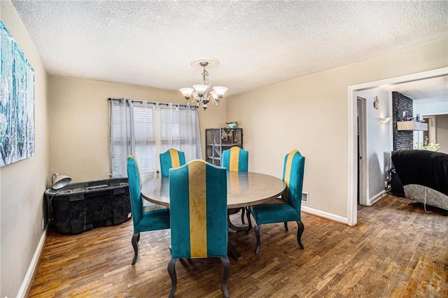 dining space featuring hardwood / wood-style floors, a textured ceiling, and a chandelier