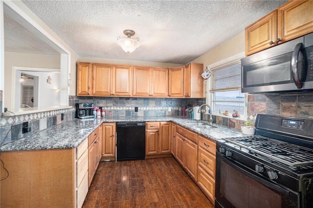 kitchen with sink, dark stone countertops, backsplash, dark hardwood / wood-style floors, and black appliances