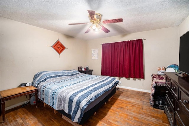 bedroom featuring hardwood / wood-style floors, a textured ceiling, and ceiling fan