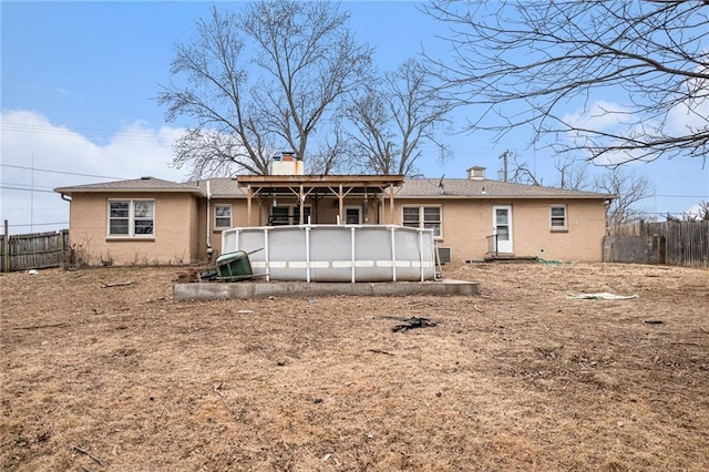 back of house with a fenced in pool