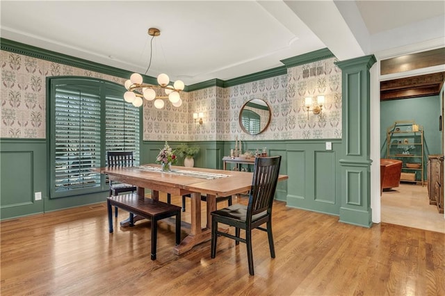 dining area featuring an inviting chandelier, light hardwood / wood-style flooring, and ornate columns