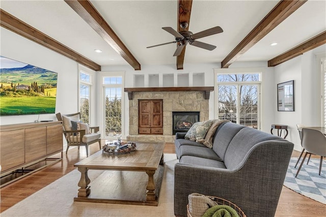 living room featuring plenty of natural light, light hardwood / wood-style floors, and beamed ceiling