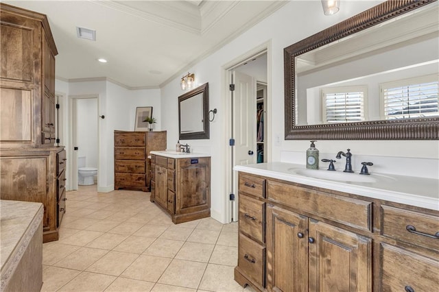 bathroom with crown molding, vanity, toilet, and tile patterned flooring